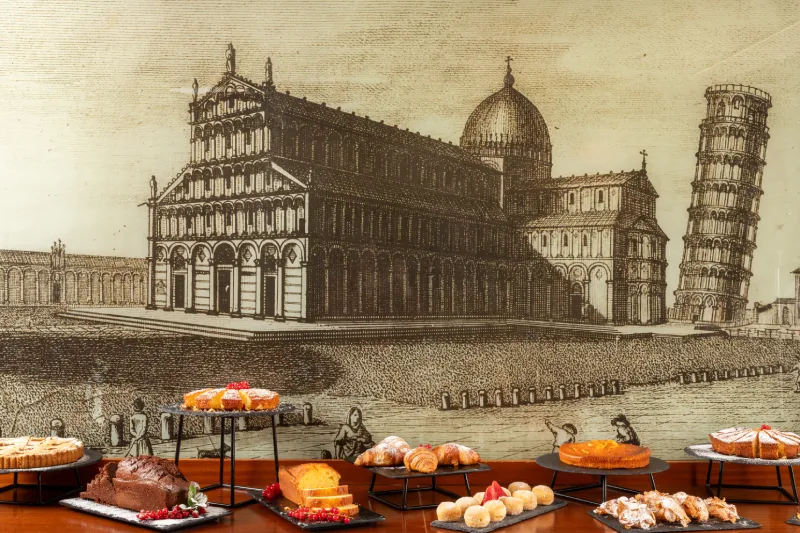 Buffet with assorted pastries and fresh croissants in front of historic Pisa illustration, elegant breakfast setting - Hotel La Pace, BZAR hotels in Pisa
